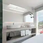 Lampe LED élégante pour miroir de maquillage installée au-dessus d'un grand miroir dans une salle de bain moderne.