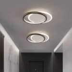 Plafonnier LED rond en fer forgé et acrylique noir suspendu dans un salon, offrant un éclairage lumineux et moderne avec une touche de sophistication noire.