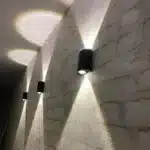 Applique LED noire en série avec des faisceaux lumineux pour couloir.
