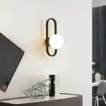 Applique murale moderne en verre sphérique noir avec globe givré.