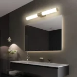 Applique LED cylindrique en acier inoxydable illuminant une salle de bain élégante et moderne.