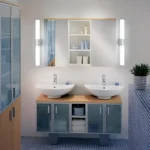 Deux appliques murales LED cylindriques encadrent un miroir dans une salle de bain moderne à double vasque.