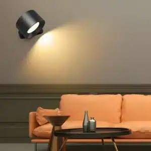 Applique murale LED noire installée au-dessus d'un canapé, ajoutant une lumière directionnelle dans le salon.