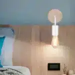 Applique murale rétro nordique en bois blanc installée dans une chambre