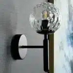 Applique murale noire avec globe lumineux effet mosaïque pour chambre.
