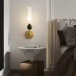 Applique murale dorée avec coude en marbre et cuivre, abat-jour en verre dépoli pour un salon chic.