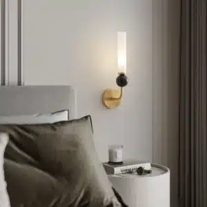 Applique murale dorée avec coude en marbre et cuivre, abat-jour en verre dépoli pour un salon moderne.