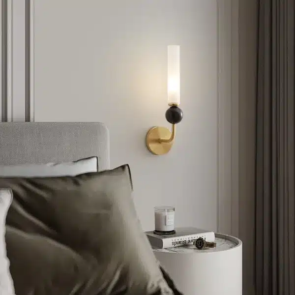 Applique murale dorée avec coude en marbre et cuivre, abat-jour en verre dépoli pour un salon moderne.