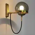 Applique murale nordique moderne avec boule en verre gris fumé et support doré.