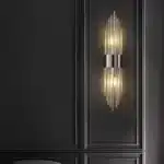 Applique murale moderne en cristal et acier noir, design faisceau, installée dans un salon au style contemporain.