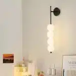 Applique murale LED en noir avec boules empilées, modèle simple, galerie.