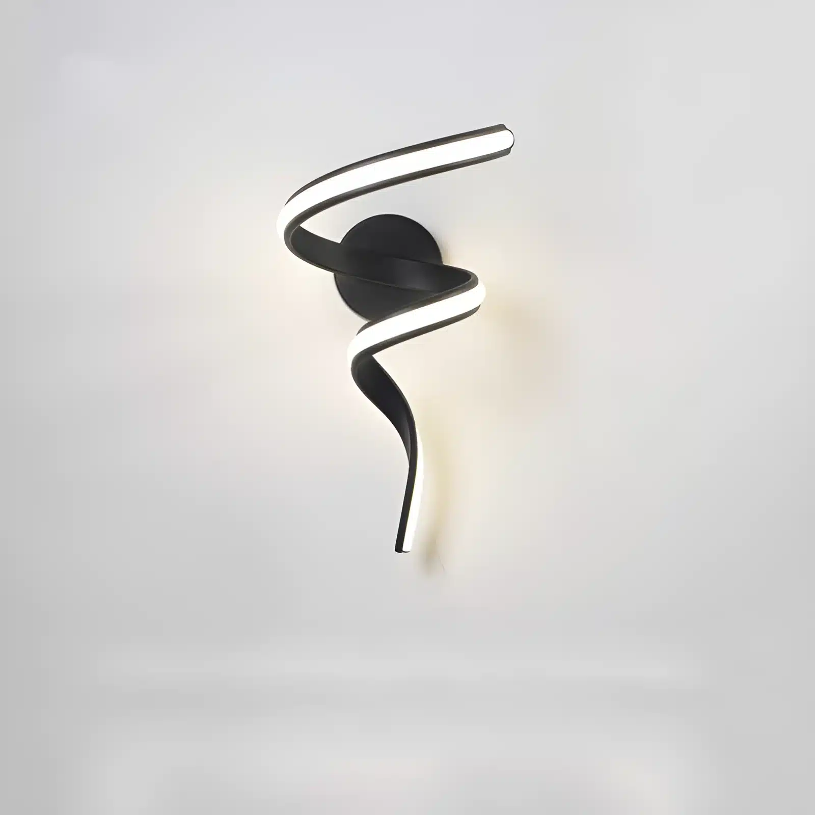 Applique murale LED en forme de tourbillon noir, montée sur un mur dans un salon minimaliste.