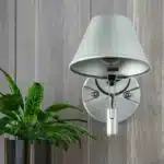 Applique murale LED en métal argenté avec abat-jour conique pour chambre.