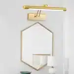 Applique murale moderne en métal doré pour miroir hexagonal dans une salle de bain moderne.