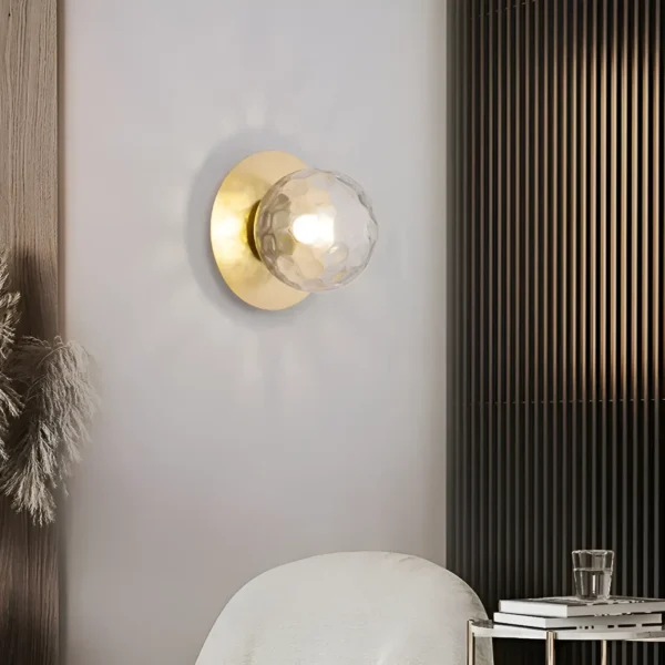 Lampe murale sphérique en noir et or avec un globe en verre texturé doré.
