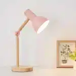 Lampe de chevet rose avec base en bois.