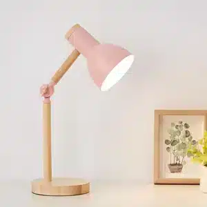 Lampe de chevet rose avec base en bois.