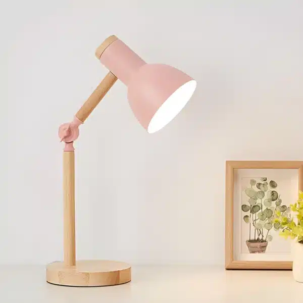 Lampe de chevet rose avec base en bois.