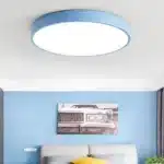 Plafonnier LED minimaliste de couleur bleu installé dans une chambre à coucher.