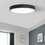 Plafonnier LED noir minimaliste dans une chambre moderne.