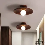 Plafonnier LED concave en bois de noyer pour un duo lumineux dans un salon moderne.
