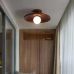Plafonnier principal en bois de noyer avec un design concave pour un éclairage raffiné.