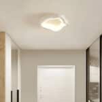 Plafonnier LED blanc en forme géométrique avec des courbes irrégulières pour salon.