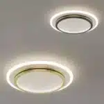 Plafonnier LED rond en fer forgé et acrylique noir, suspendu au plafond d'un salon, diffusant une lumière claire et moderne