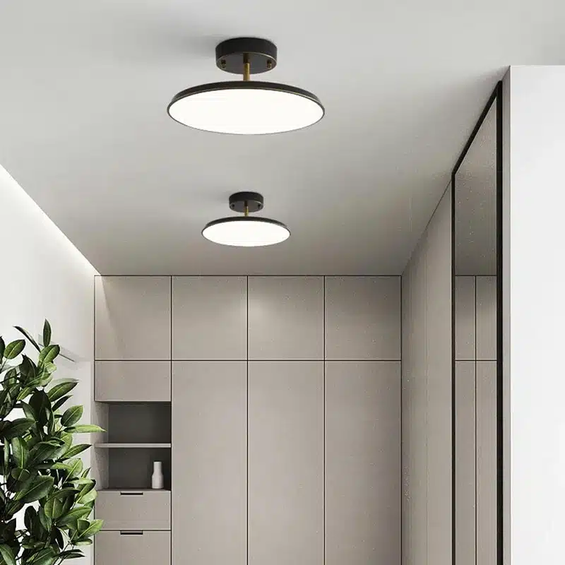Plafonnier moderne Disque Céleste en cuivre et acrylique noir, installé dans un salon, offrant un éclairage clair et homogène avec une touche contemporaine.