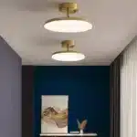 Plafonnier moderne Disque Céleste en cuivre et acrylique, suspendu dans un salon, diffusant une lumière élégante et homogène