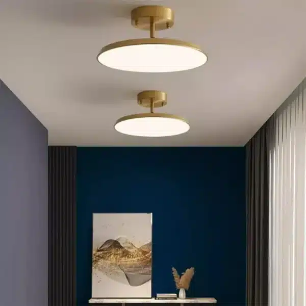 Plafonnier moderne Disque Céleste en cuivre et acrylique, suspendu dans un salon, diffusant une lumière élégante et homogène