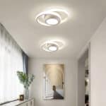 Plafonniers modernes blancs en forme d'orbe dans un salon avec une plante et un tableau d'arche.