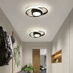 Plafonniers modernes noirs en forme d'orbe dans un couloir minimaliste.