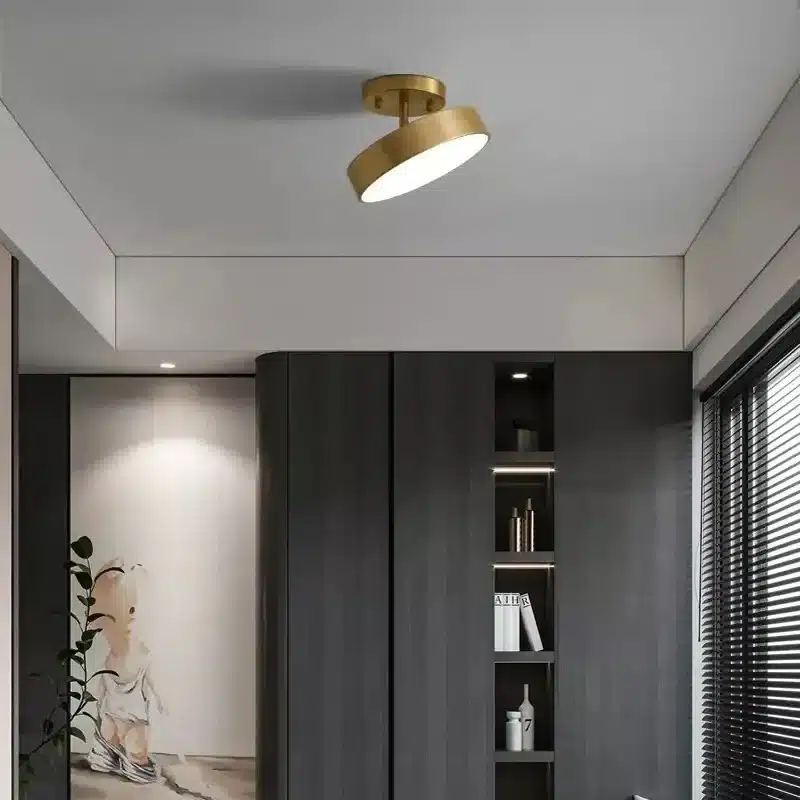 Plafonnier Nordique en Cuivre doré éclairant une pièce moderne avec des meubles sombres